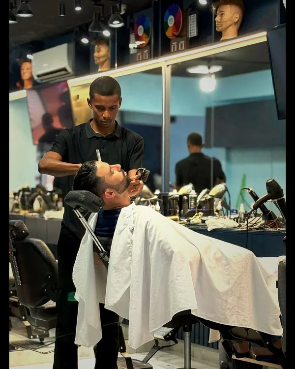 Barbeiro atendendo cliente na Hebreus Barbershop — barbearia em Goiânia